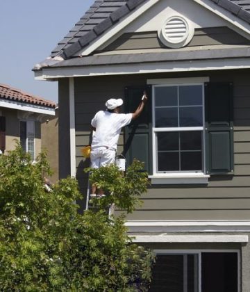 Professional painter painting the trim on a house.