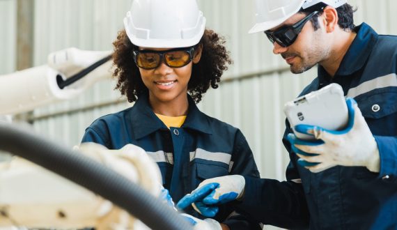 technician maintenance manager or Industrial engineer male and female working and control robotic in heavy industry, teamwork on project